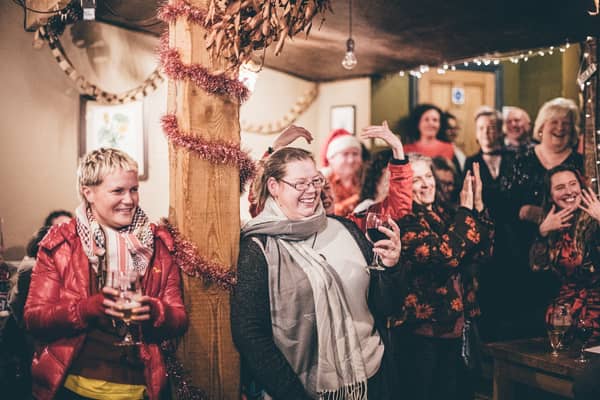 A crowd in the bar raising their glasses