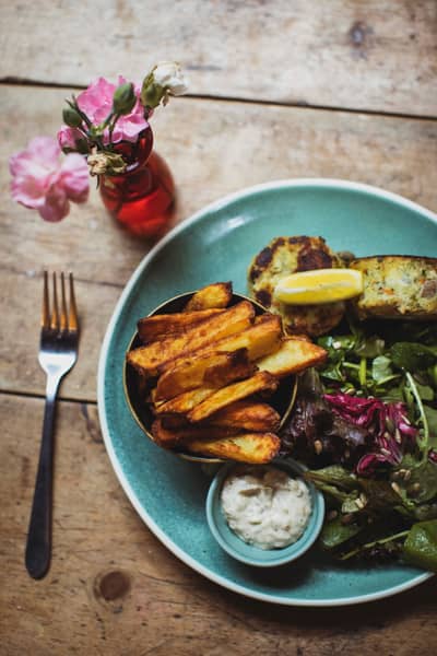 Chips, salad and a dip on a blue plate, with flowers
