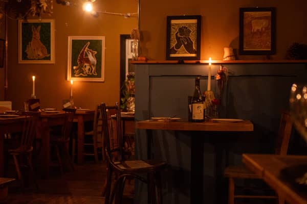 The dining room lit by candles, pictures on the walls